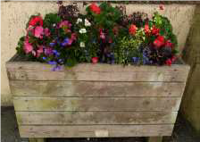 colourful flowers in a brown wooden tub